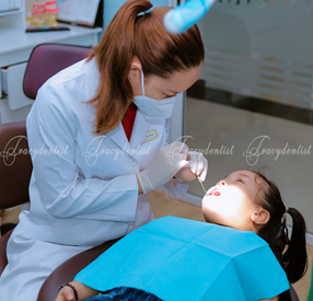 Bác sĩ đang thăm khám để niềng răng trẻ em tại Nha Khoa Tracy